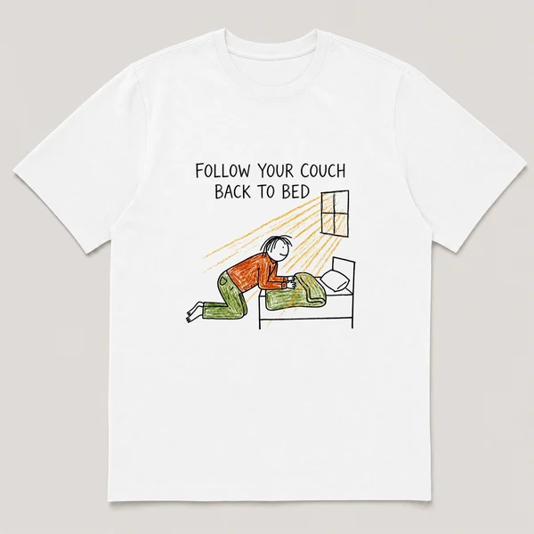Front view of a White Tee printed with guy crawls back into bed at noon while sunlight streams through a window and the caption FOLLOW YOUR COUCH BACK TO BED